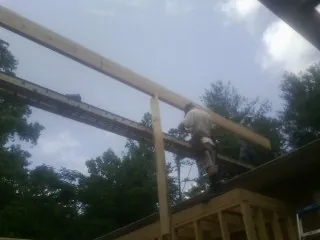Carpenter setting a ridge beam over a new addition frame — Ice Dam Removal by Roofing Brothers in Flintstone